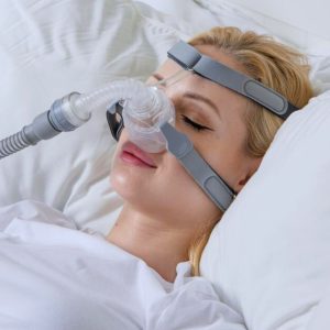 Woman wearing BMC N5H Nasal Mask in bed | CPAP.co.uk